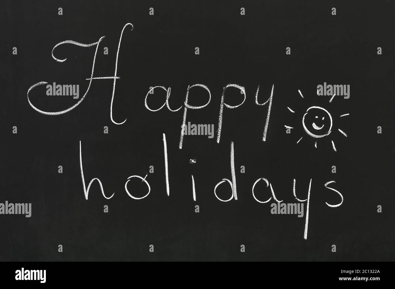 Bonnes vacances de phrase à la main sur le tableau noir de l'école Banque D'Images