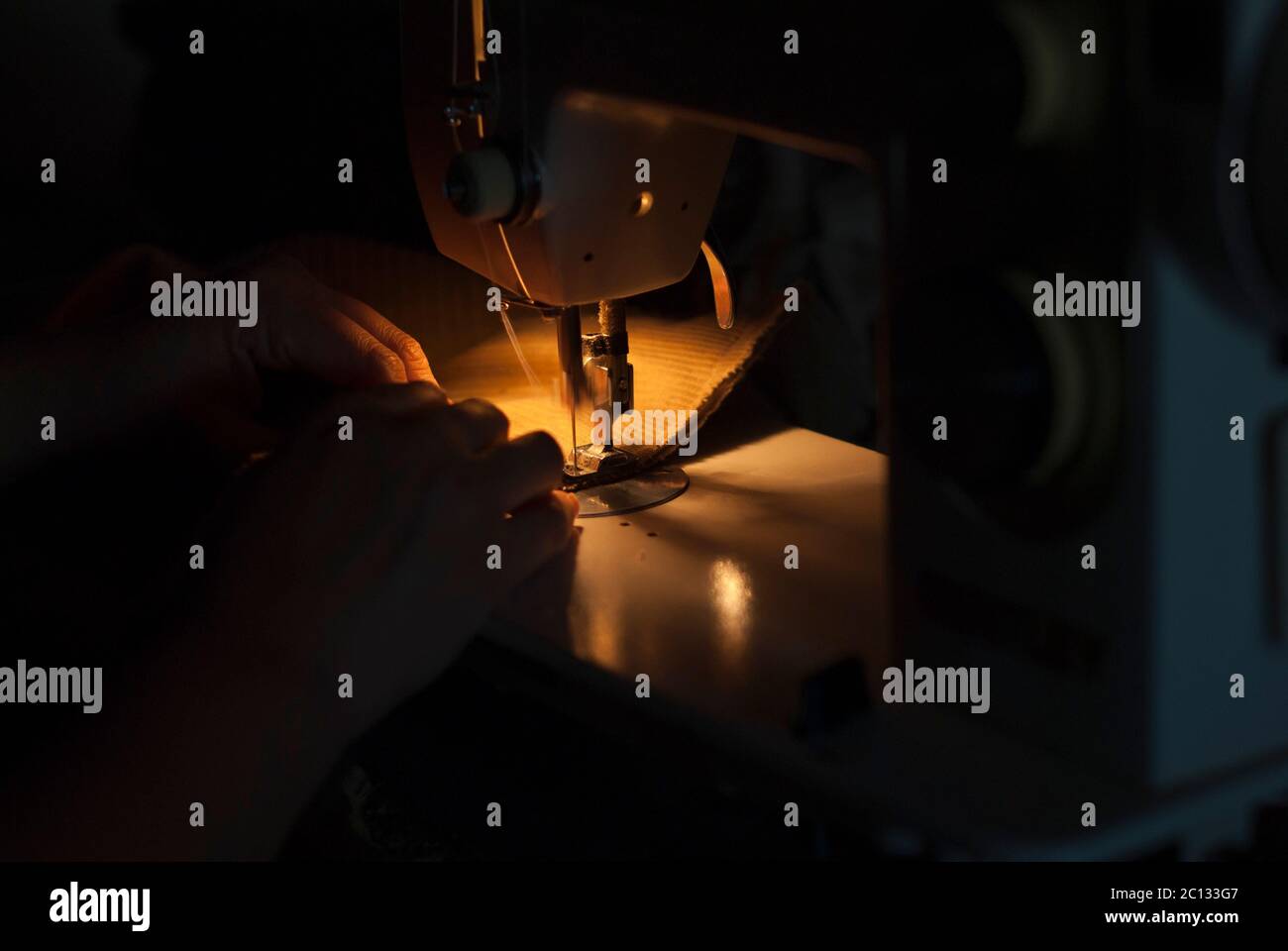 Main de femme travaillant sur une machine à coudre Banque D'Images