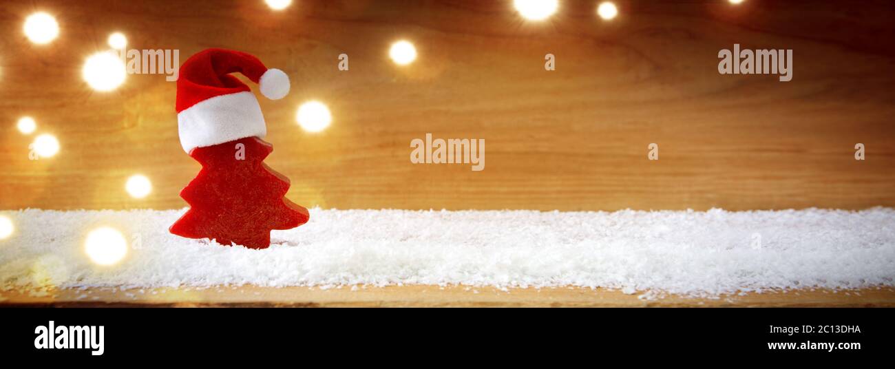 Chapeau de Père Noël et sapin rouge sur la neige. Banque D'Images