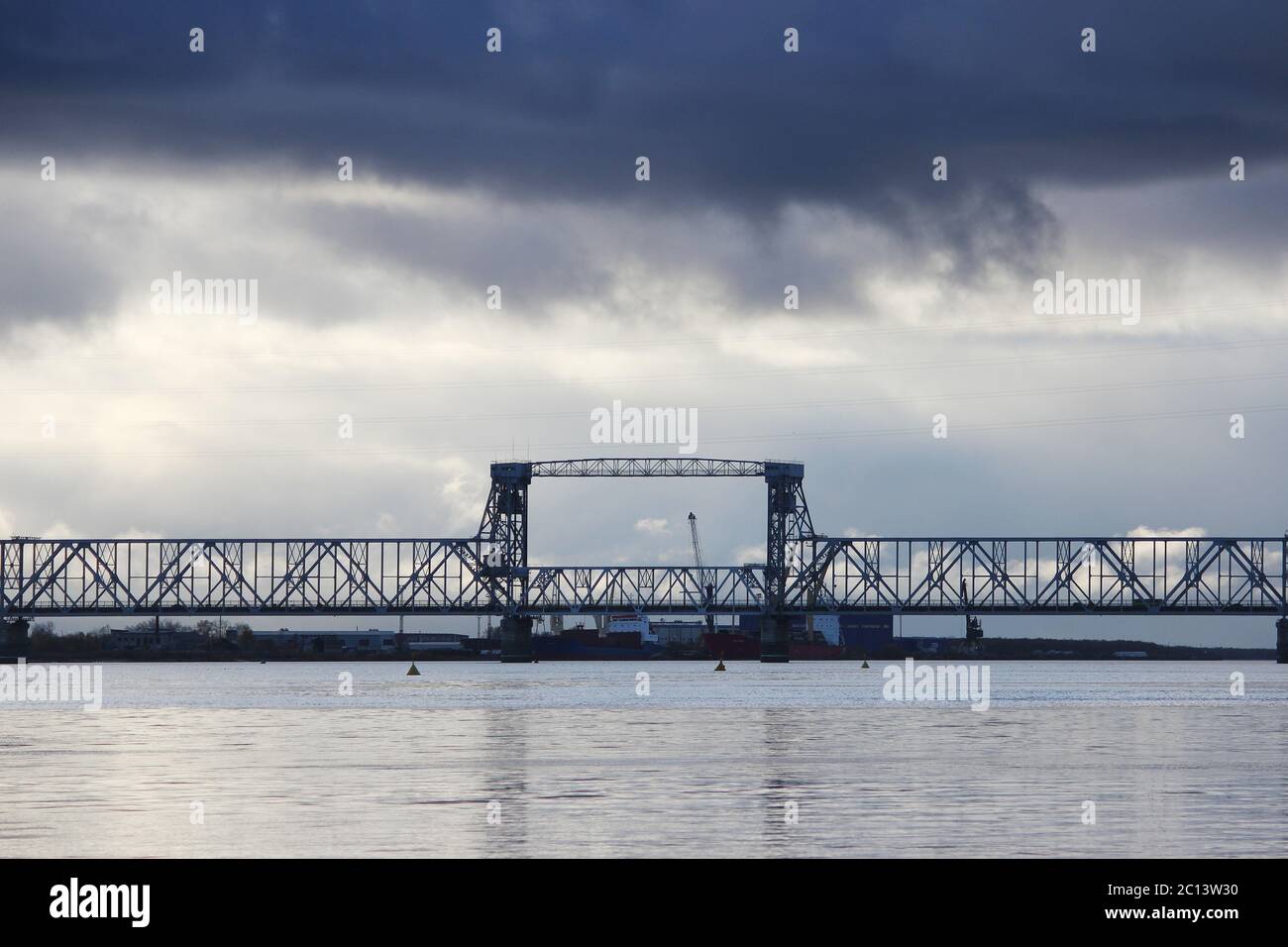 Les cumulus blancs passent le pont au-dessus de la rivière Dvina du Nord. Banque D'Images