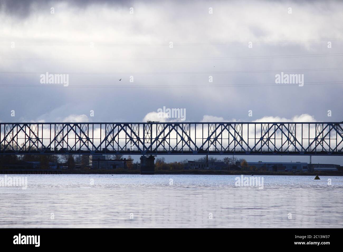 Les cumulus blancs passent le pont au-dessus de la rivière Dvina du Nord. Banque D'Images