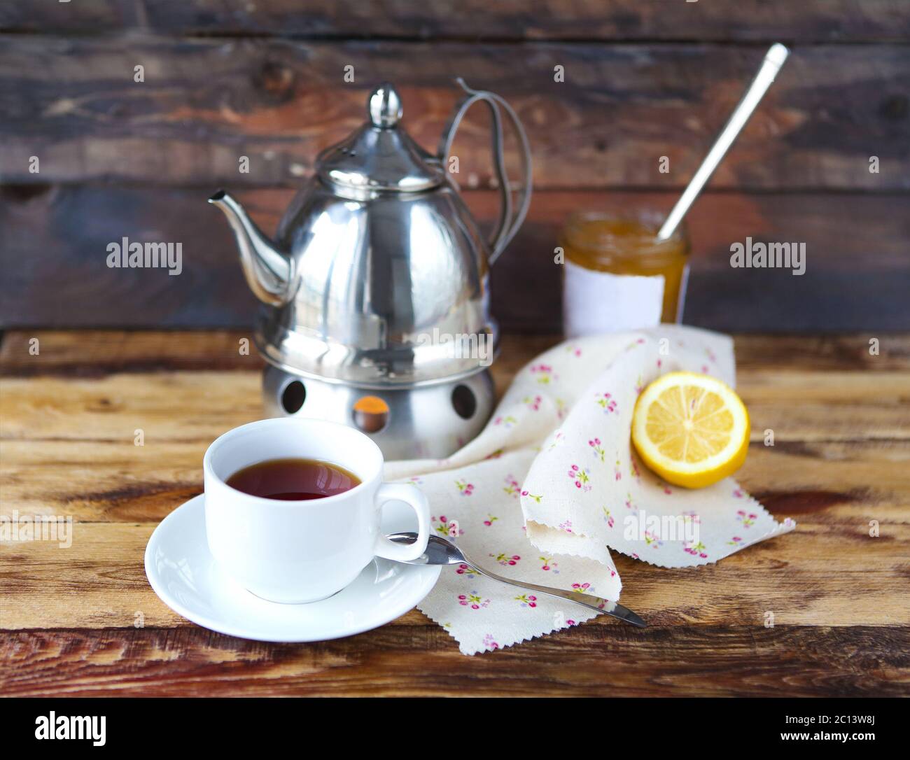 Tasse de thé noir avec un citron, une théière et de la confiture Banque D'Images