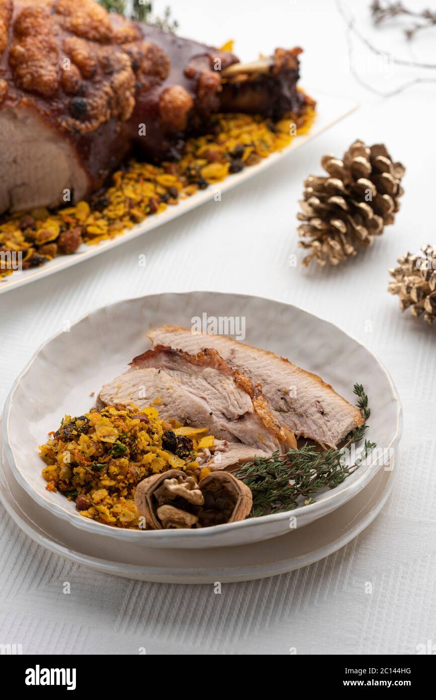 tranches de jambon d'épaule de porc rôties avec des noix sur un plat blanc et de la nourriture sur fond Banque D'Images