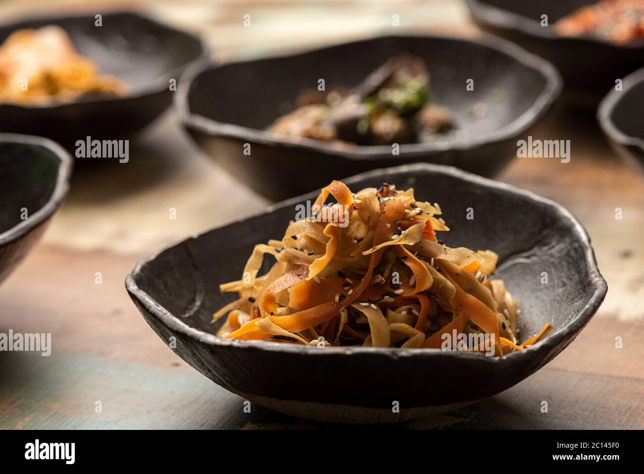 kimchi fermenté asiatique chou alimentaire fermenté sur un bol noir et autres ingrédients sur fond Banque D'Images