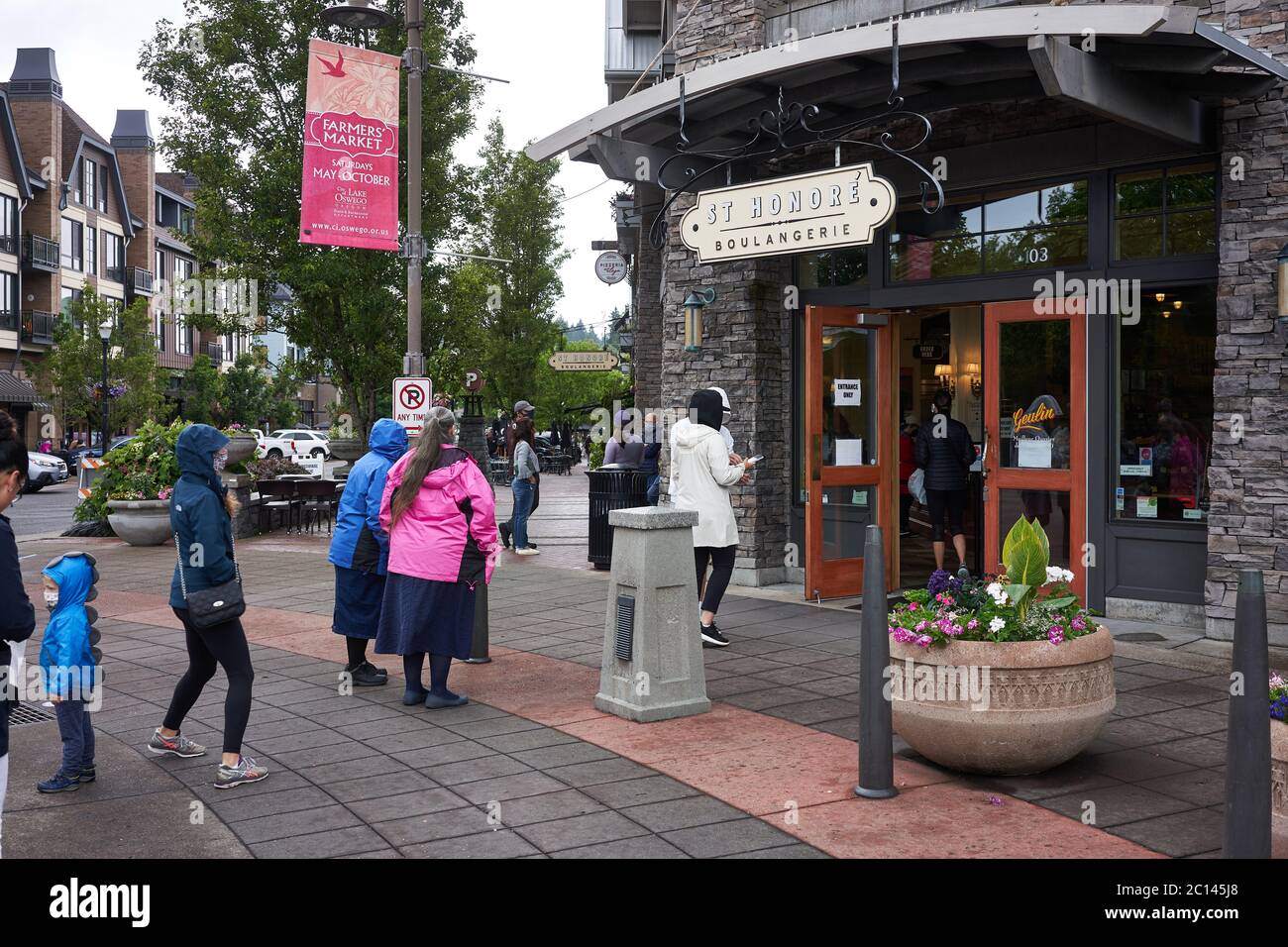 Les clients masqués font la queue et pratiquent la distanciation sociale à l'extérieur d'une boulangerie et d'un café du lac Oswego, Oregon, le 6/13/2020, pendant la pandémie de COVID-19. Banque D'Images