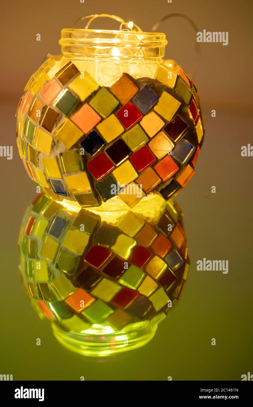 La bouteille en verre mosaïque colorée, qui se reflète sur le tableau. Banque D'Images