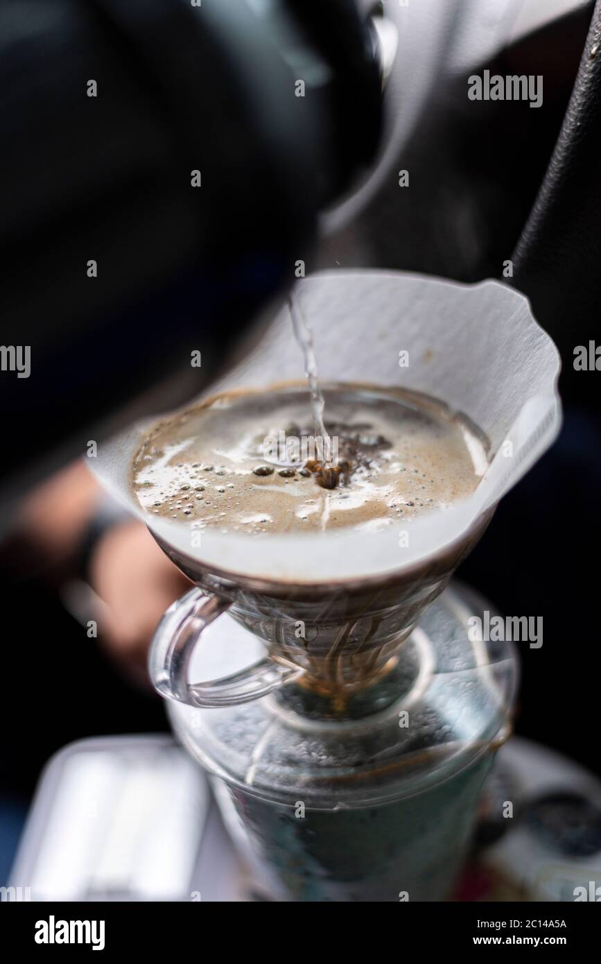 café eau versant préparation avec filtre avec une bouteille d'eau thermique en plastique à l'intérieur d'une voiture avec belle lumière et profondeur de champ Banque D'Images