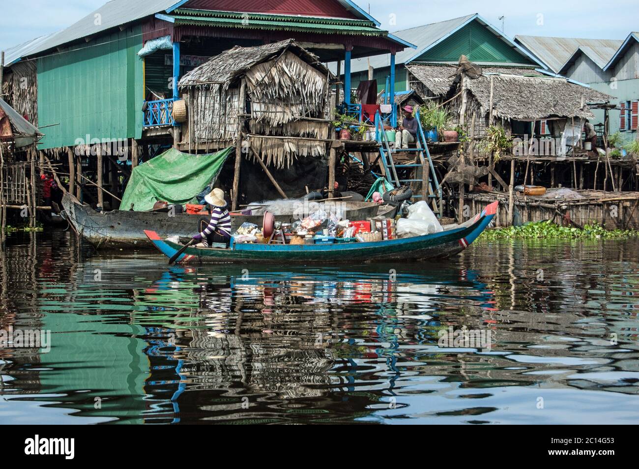 Kampong Phluk, Cambodge - 4 décembre 2011 : une femme pagayant un bateau en bois lourdement chargé à travers le village flottant de Kampong Phluk sur le Tonlie Banque D'Images