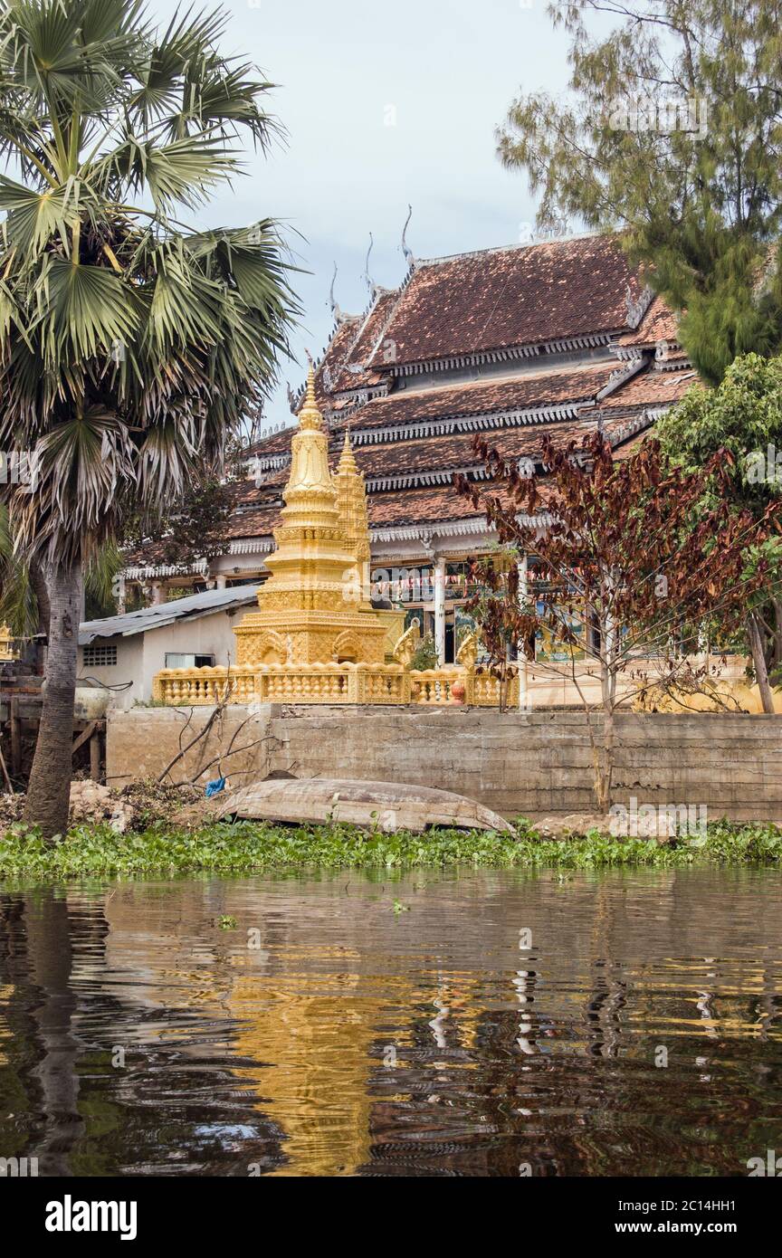 Une pagode dorée, ou stupa, à côté d'un temple bouddhiste dans le village flottant de Kompong Phluk, le lac Tonle SAP, Cambodge. Banque D'Images