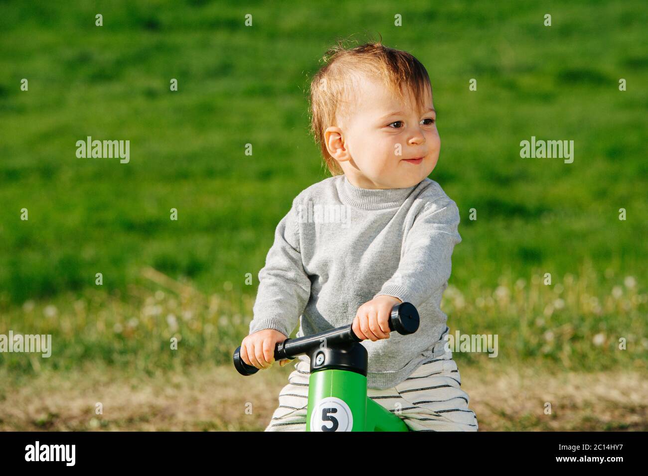 Jolly petit enfant sur un vélo à trois roues s'appréciant. Banque D'Images