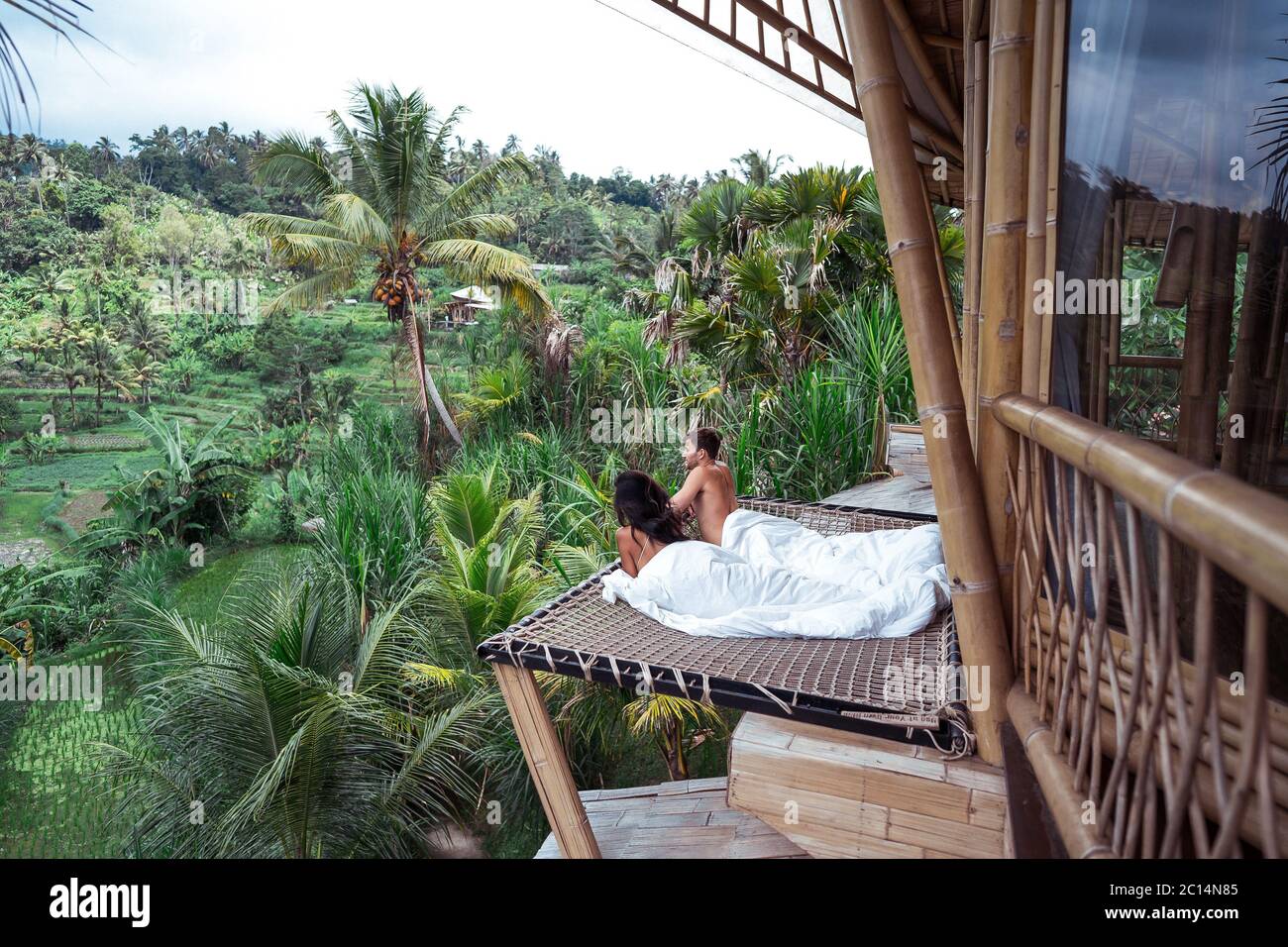 Couple appréciant les vacances du matin sur la jungle tropicale villa  bungalow regardant les palmiers vacances relaxantes à Bali, Indonésie.  Couple pour leur lune de miel Photo Stock - Alamy