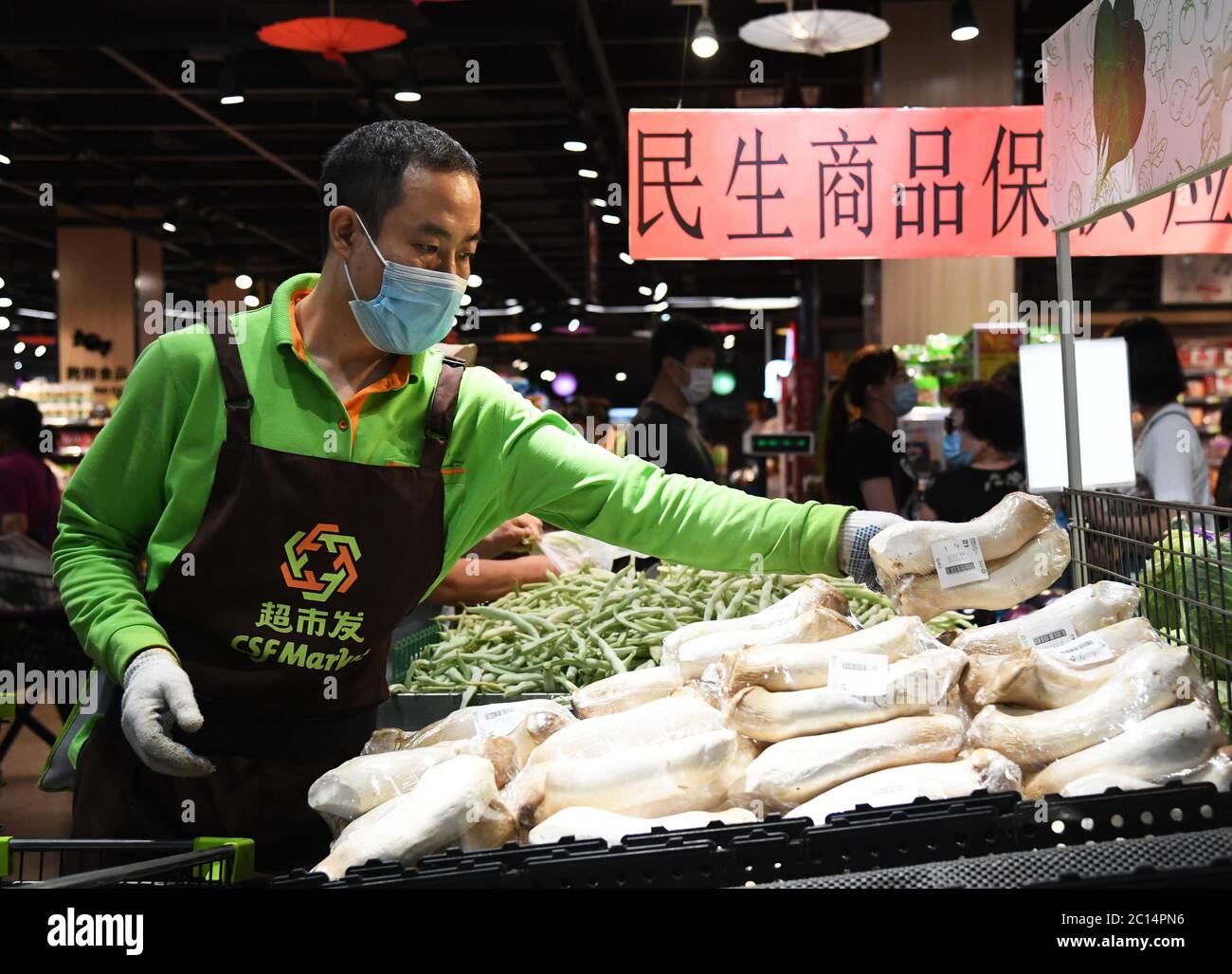 Pékin, Chine. 14 juin 2020. Un membre du personnel place des champignons comestibles dans une succursale de supermarché Chaoshifa dans le district de Haidian, à Beijing, capitale de la Chine, le 14 juin 2020. Chaoshifa, une chaîne de supermarchés, a réussi à assurer un approvisionnement direct et adéquat en légumes et fruits des bases de production autour de Beijing, suite à la suspension temporaire du marché de gros de Xinfadi samedi dans la capitale. Crédit: REN Chao/Xinhua/Alay Live News Banque D'Images Pékin, Chine. 14 juin 2020. Un membre du personnel place des champignons comestibles dans une succursale de supermarché Chaoshifa dans le district de Haidian, à Beijing, capitale de la Chine, le 14 juin 2020. Chaoshifa, une chaîne de supermarchés, a réussi à assurer un approvisionnement direct et adéquat en légumes et fruits des bases de production autour de Beijing, suite à la suspension temporaire du marché de gros de Xinfadi samedi dans la capitale. Crédit: REN Chao/Xinhua/Alay Live News Banque D'Images
