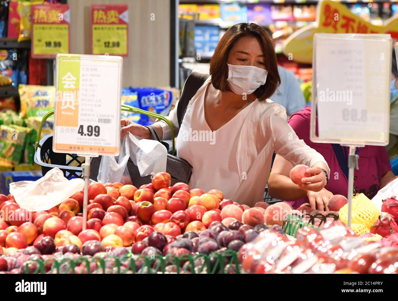 Pékin, Chine. 14 juin 2020. Un client achète des fruits dans une succursale de supermarché Chaoshifa dans le district de Haidian à Beijing, capitale de la Chine, le 14 juin 2020. Chaoshifa, une chaîne de supermarchés, a réussi à assurer un approvisionnement direct et adéquat en légumes et fruits des bases de production autour de Beijing, suite à la suspension temporaire du marché de gros de Xinfadi samedi dans la capitale. Crédit: REN Chao/Xinhua/Alay Live News Banque D'Images Pékin, Chine. 14 juin 2020. Un client achète des fruits dans une succursale de supermarché Chaoshifa dans le district de Haidian à Beijing, capitale de la Chine, le 14 juin 2020. Chaoshifa, une chaîne de supermarchés, a réussi à assurer un approvisionnement direct et adéquat en légumes et fruits des bases de production autour de Beijing, suite à la suspension temporaire du marché de gros de Xinfadi samedi dans la capitale. Crédit: REN Chao/Xinhua/Alay Live News Banque D'Images