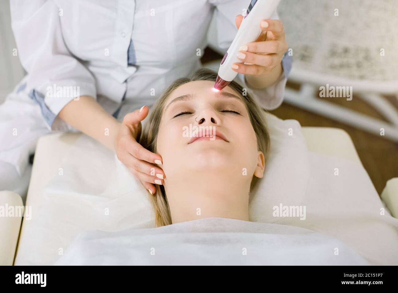 Photo de jolie femme en train de devenir un signe de naissance ou un filet vasculaire enlevé par laser au salon de beauté. Dermatologue professionnel utilisant des grains de beauté à laser Banque D'Images