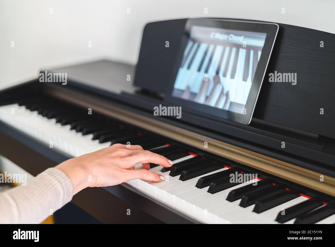 femme caucasienne apprenant à jouer du piano avec des leçons vidéo. Concept d'apprentissage virtuel Banque D'Images
