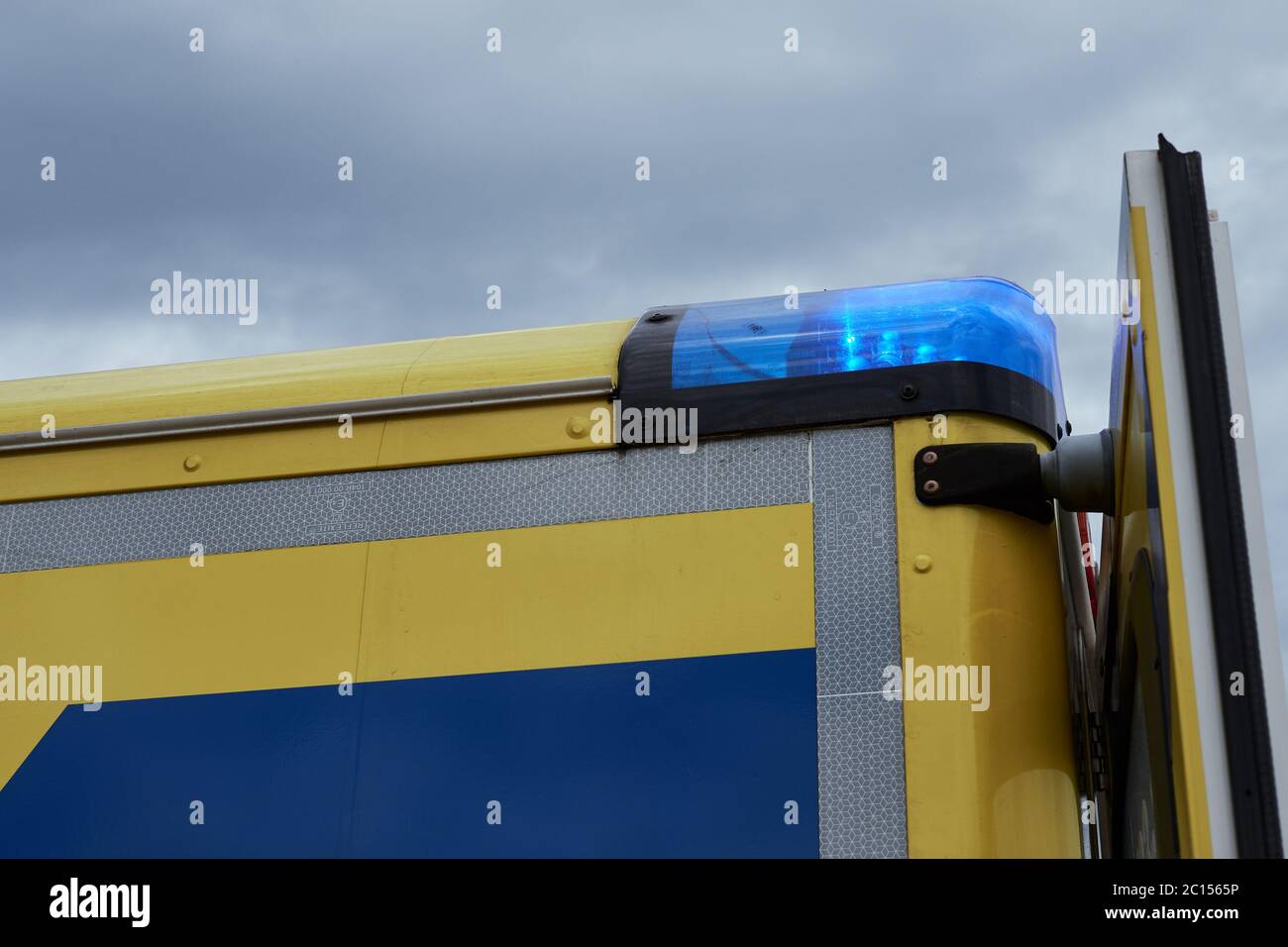Gros plan d'un véhicule d'urgence avec des feux bleus allumés contre le ciel couvert Banque D'Images