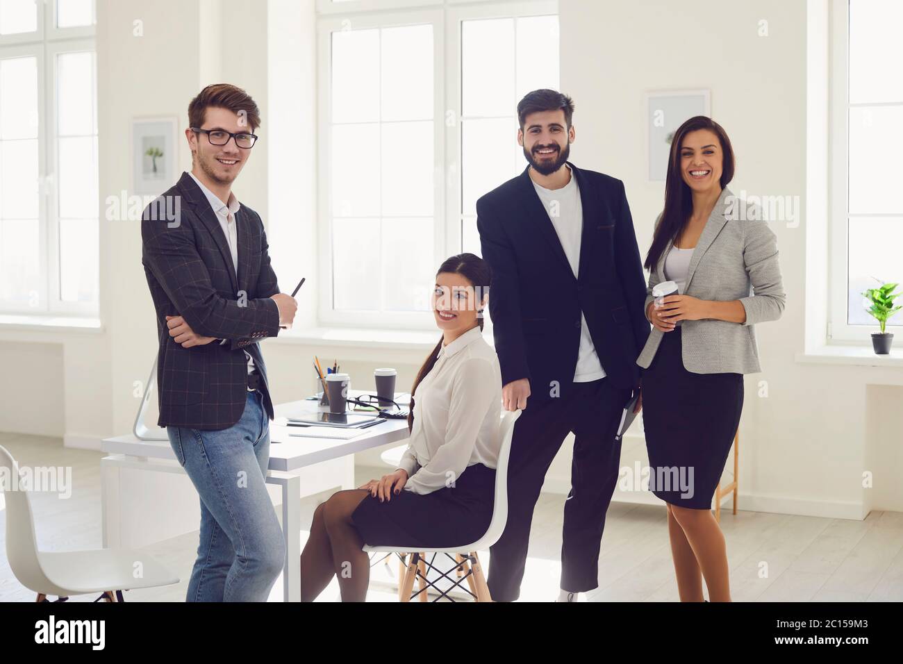 Groupe de gens d'affaires debout regardant sourire debout à un table dans le bureau Banque D'Images