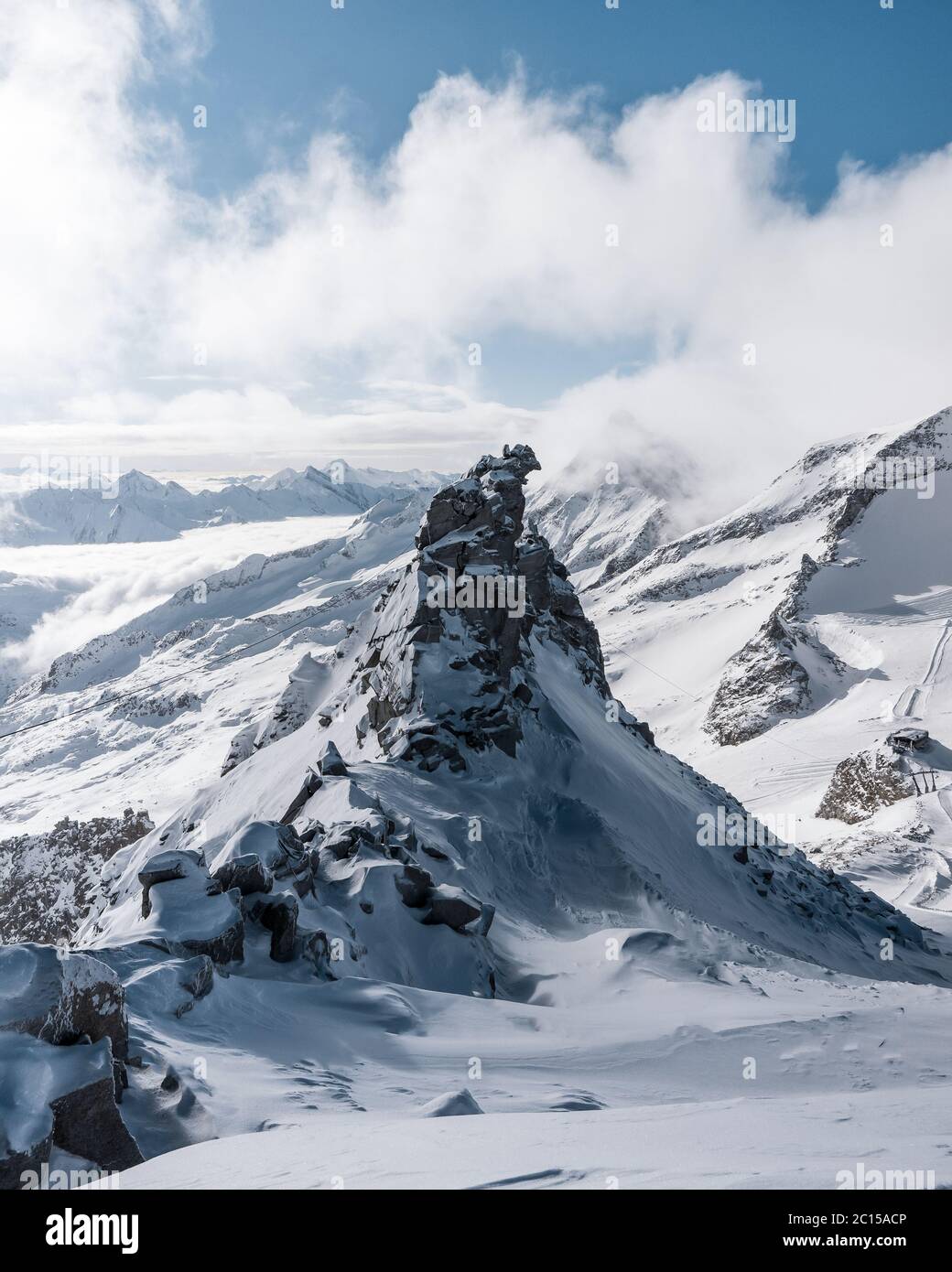 Le voyageur contemple un paysage de montagne enneigé. L'homme reste au-dessus de la brume intense dans la vallée profonde. La randonnée dans la nature pure est l'activité de loisirs populaire Banque D'Images