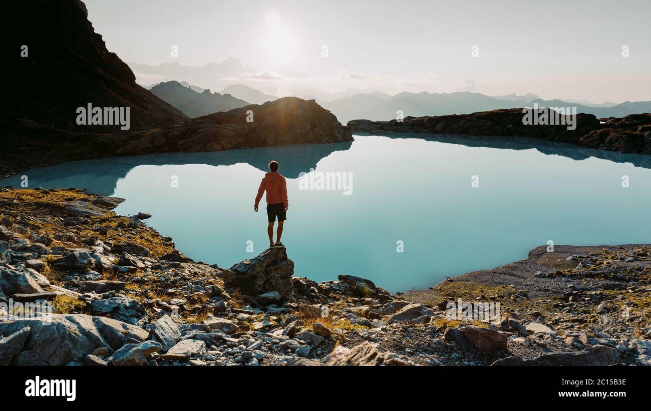 Un alpiniste au sommet d'un rocher et regardant le paysage alpin de montagne d'été. Randonneur ou grimpeur sur une ascension aventure jusqu'au sommet Banque D'Images