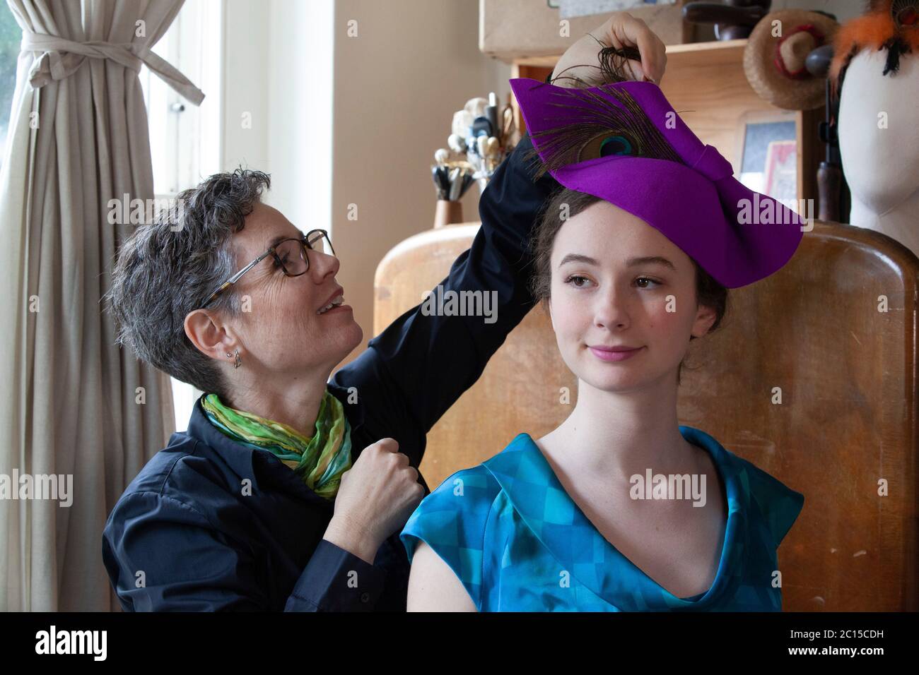 Londres, Royaume-Uni, 14 juin 2020 : la lailliner Leanne Fredrick prépare un de ses chapeaux, modelé par sa fille Eliana, pour la collecte de fonds sur les médias sociaux 'Royal Ascot at Home' qui se tiendra du 16 au 20 juin. Comme l'événement de course de chevaux et de société a été annulé en raison des mesures de sécurité de distanciation sociale du coronavirus, les gens sont encouragés à poster des photos de leurs chapeaux et de leurs tenues avec le hestag #StyledWithThanks et faire un don aux organismes de bienfaisance Covid-19 choisis par Ascot. Anna Watson/Alay Live News. Banque D'Images