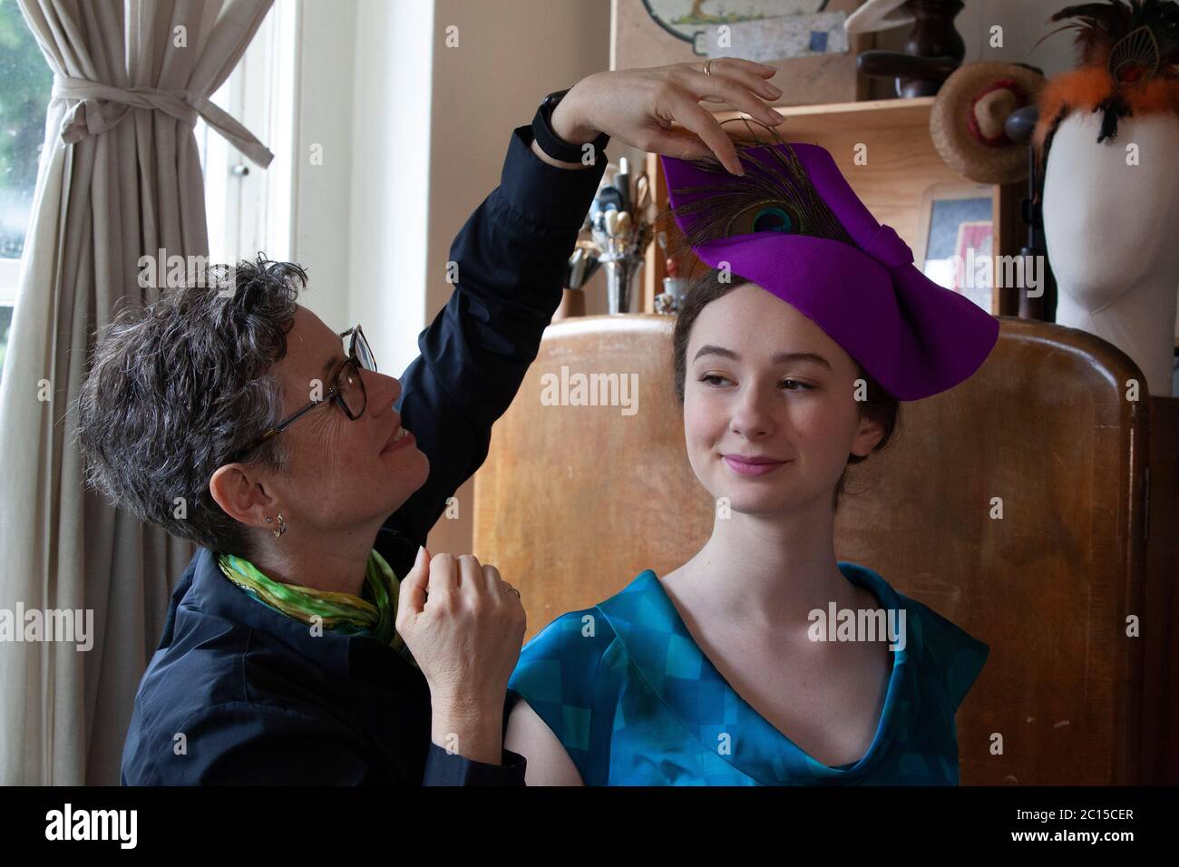 Londres, Royaume-Uni, 14 juin 2020 : la lailliner Leanne Fredrick prépare un de ses chapeaux, modelé par sa fille Eliana, pour la collecte de fonds sur les médias sociaux 'Royal Ascot at Home' qui se tiendra du 16 au 20 juin. Comme l'événement de course de chevaux et de société a été annulé en raison des mesures de sécurité de distanciation sociale du coronavirus, les gens sont encouragés à poster des photos de leurs chapeaux et de leurs tenues avec le hestag #StyledWithThanks et faire un don aux organismes de bienfaisance Covid-19 choisis par Ascot. Anna Watson/Alay Live News. Banque D'Images