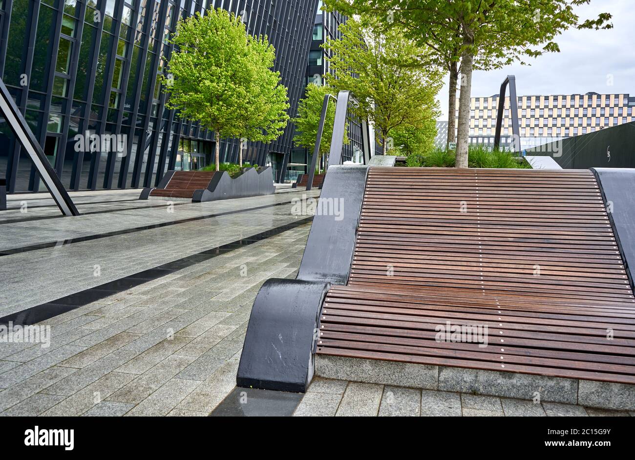 Banc moderne dans le parc près du bâtiment de bureau Banque D'Images