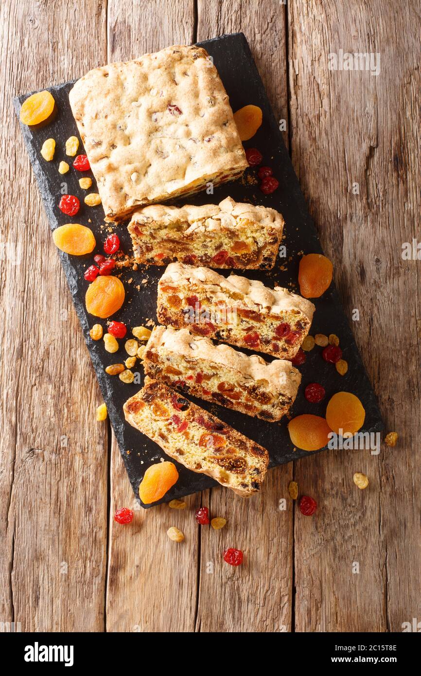 Muffin aux fruits d'hiver maison aux abricots séchés, baies, raisins, figues cerises sur une table en ardoise. Vue verticale du dessus Banque D'Images