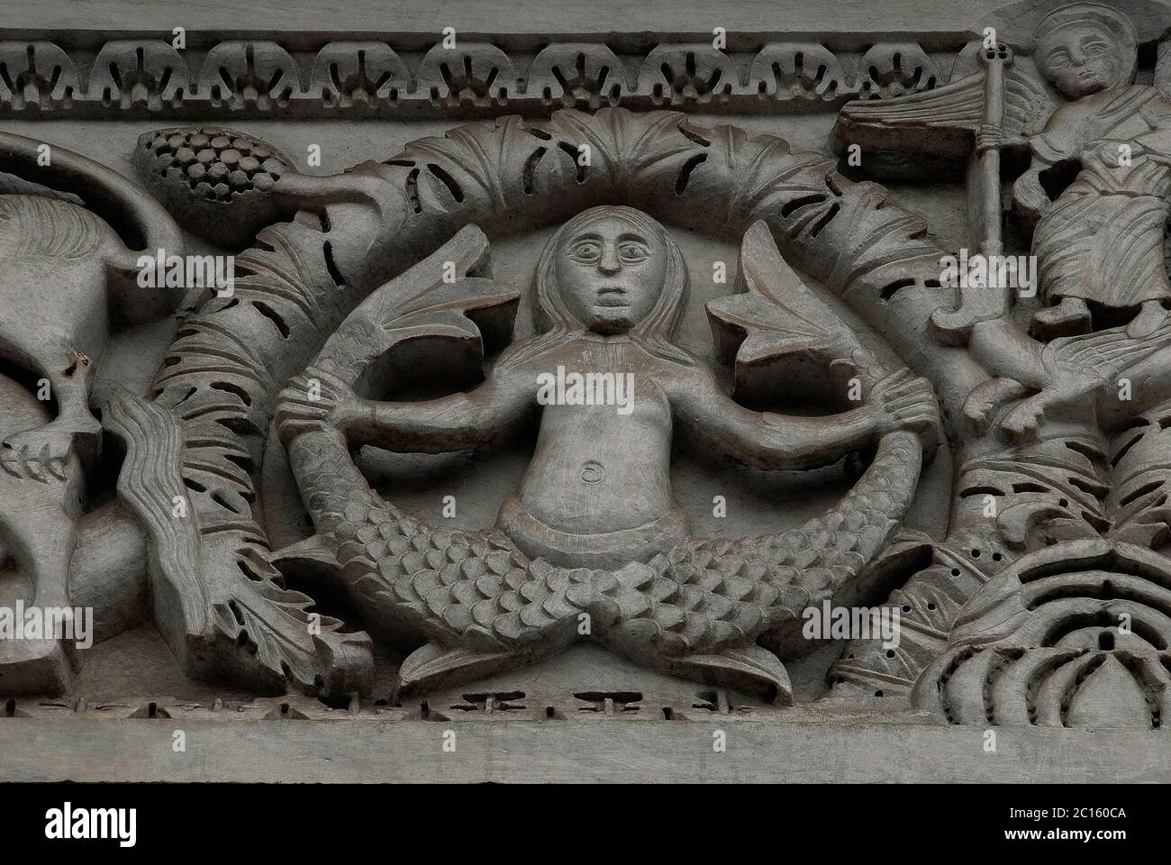 Sirène ou merman avec deux queues. Au milieu d'une sculpture médiévale en marbre de style roman pisan ajoutée à la façade ouest de la Chiesa di San Michele à Lucques, Toscane, Italie, dans les années 1200 Banque D'Images