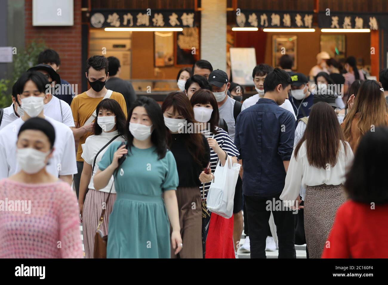 Tokyo, Japon. 14 juin 2020. Des personnes portant des masques de visage marchent dans une rue à Tokyo, Japon, 14 juin 2020. Le gouvernement métropolitain de Tokyo a confirmé dimanche 47 nouveaux cas d'infections à COVID-19, quelques jours seulement après Tokyo Gov. Yuriko Koike a levé l'alerte de Tokyo au sujet de la pandémie pour permettre à toutes les entreprises de rouvrir. Crédit : du Xiaoyi/Xinhua/Alay Live News Banque D'Images