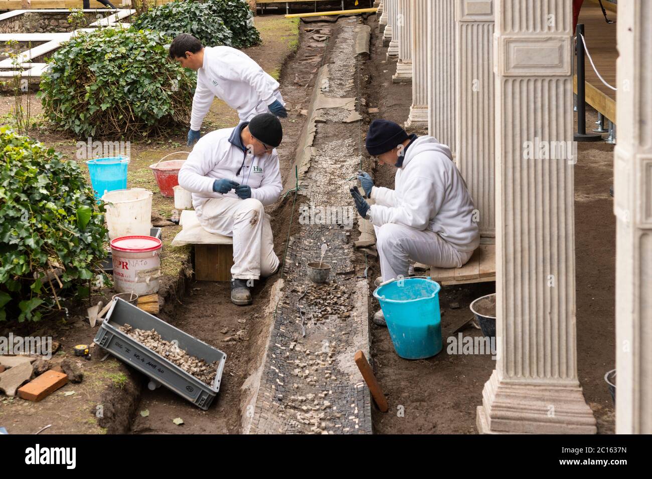 Archéologues réparant et rétablissant le carrelage en mosaïque dans la Maison de Giulia Felice (Villa di Giulia Felice) dans l'ancienne ville de Pompéi, en Italie Banque D'Images