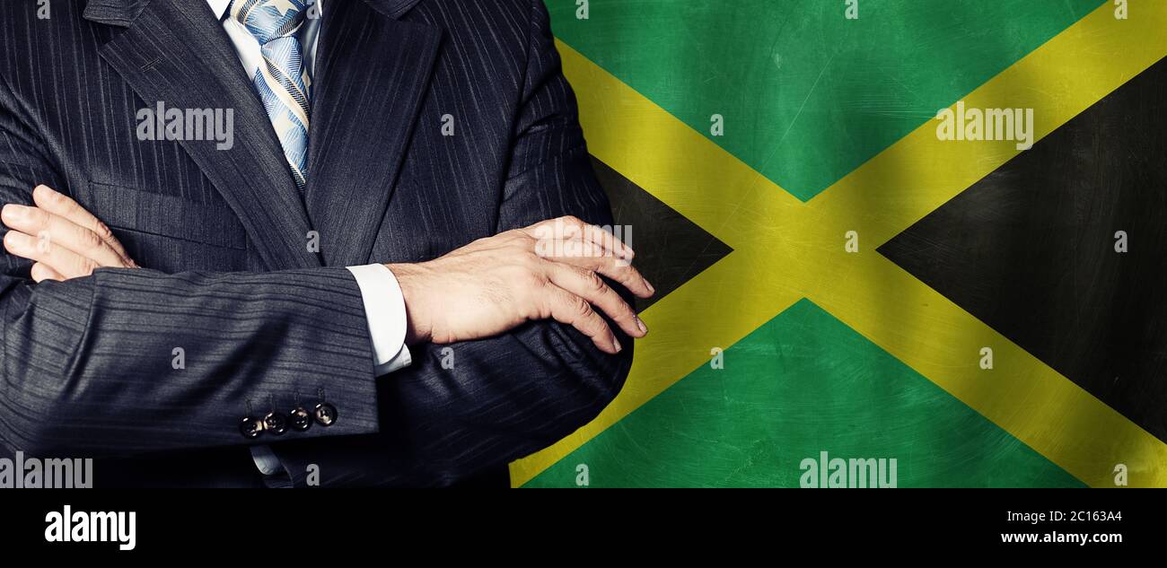 Les hommes ont des mains contre le drapeau jamaïcain, le monde des affaires, la politique et l'éducation en Jamaïque concept Banque D'Images