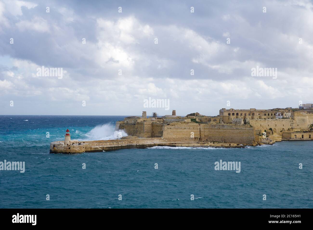 VALLETTA, MALTE - 31 décembre 2019 : vue du fort St Elmo sur le Grand Port de Ricasoli, brise-lames et phare rouge pendant les vagues fortes Banque D'Images