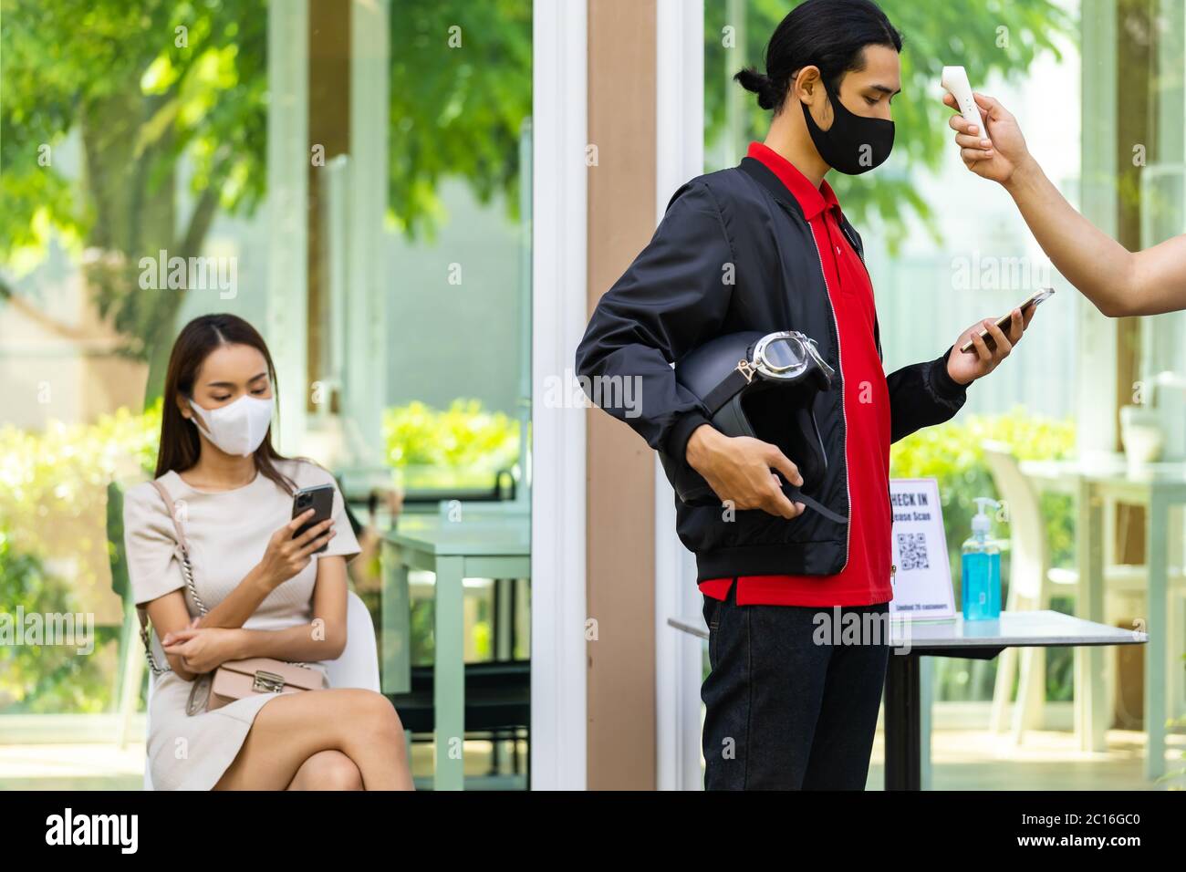 Prenez la température pour le client avec masque avant d'entrer dans le restaurant avec la file d'attente de distance sociale dans la ligne nouveau normal après le coronavirus covid-19 PAN Banque D'Images