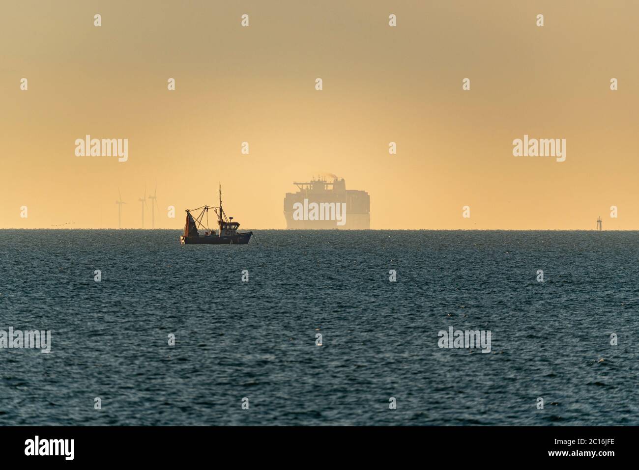 Navire-conteneur Algeciras HMM sortant de la brume marine au lever du soleil sur l'estuaire de la Tamise à Southend on Sea, Essex, Royaume-Uni. Tamise. Émergent Banque D'Images