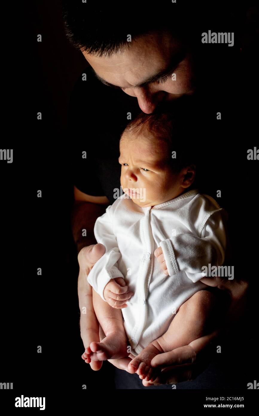Pere Tenant Son Fils De 15 Jours Dans La Main Sur Fond Noir Bebe Couche Sur Son Pere Photo Stock Alamy