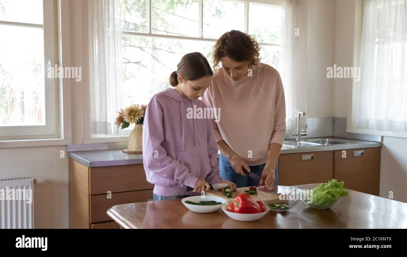 Mère et fille de l'adolescence cuisinant ensemble dans la cuisine Banque D'Images