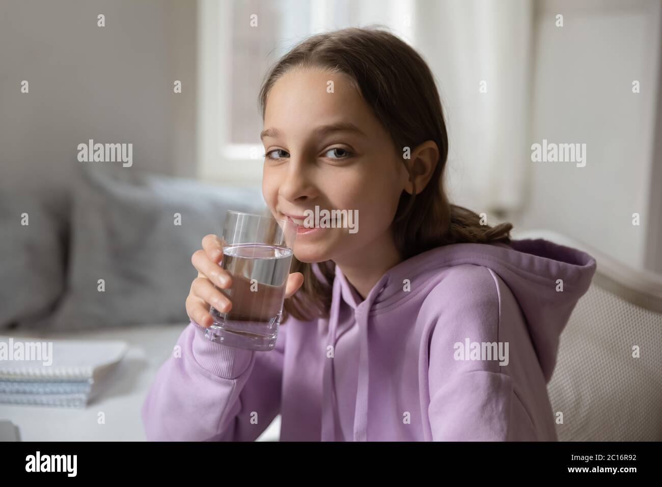 Portrait d'une adolescente souriante qui boit de l'eau minérale Banque D'Images