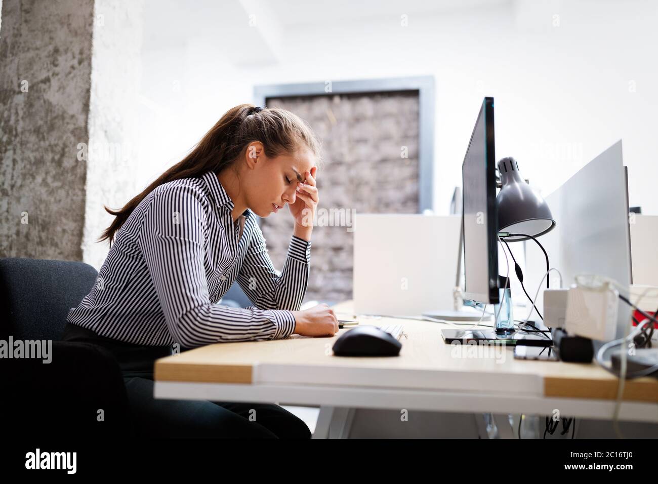Surmené et frustré jeune femme en face de computer in office Banque D'Images