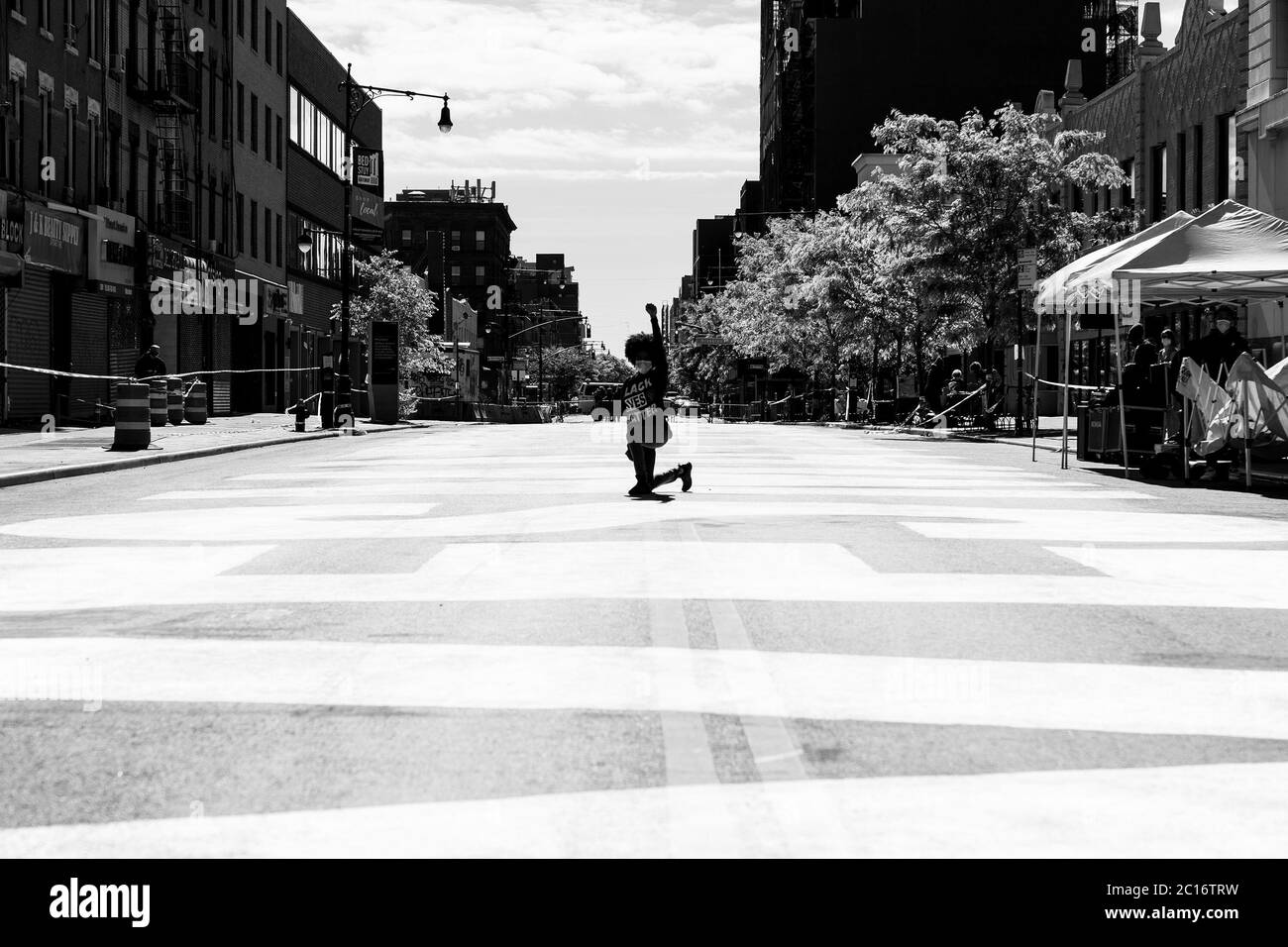 New York, États-Unis. 14 juin 2020. Une femme portant la chemise #BLM pose avec la main trempée sur Fulton Street peint énorme Black Lives Matter slogan lors de la cérémonie de dévoilement à Bedford-Stuyvesant. La murale complète s'étend de l'avenue Marcy à l'avenue New York sur 375 pieds. (Photo de Lev Radin/Pacific Press) crédit: Agence de presse du Pacifique/Alamy Live News Banque D'Images