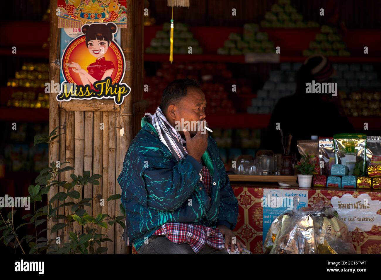 Un homme assis à l'extérieur d'un magasin et fuyant dans le village chinois thaïlandais de Ban Rak, province de Mae Hong son, dans le nord de la Thaïlande. Banque D'Images Un homme assis à l'extérieur d'un magasin et fuyant dans le village chinois thaïlandais de Ban Rak, province de Mae Hong son, dans le nord de la Thaïlande. Banque D'Images