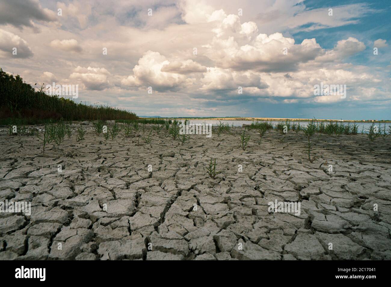 Sol sec avec un orage en arrière-plan Banque D'Images