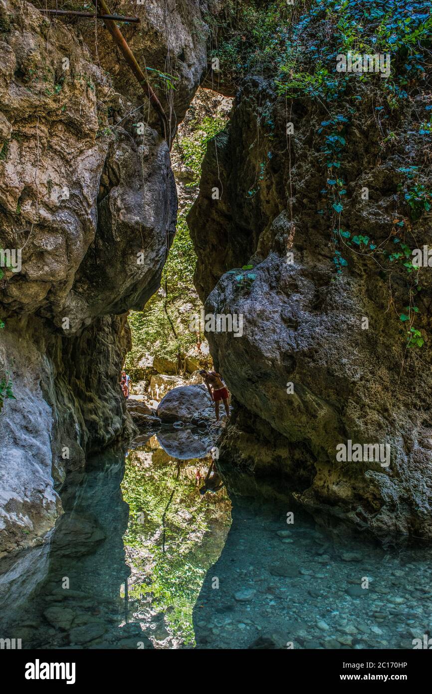 Un étang tranquille entre la formation rocheuse avec un homme qui réfléchit sur l'eau près de Lefkada, en Grèce Banque D'Images