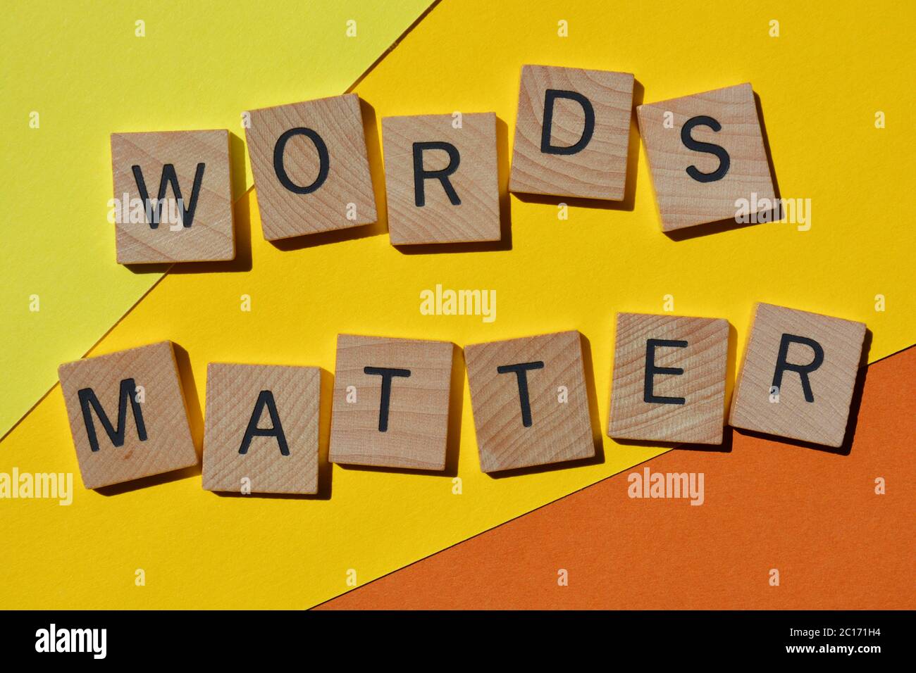 Les mots comptent, en lettres de l'alphabet en bois isolées sur fond jaune vif et orange Banque D'Images