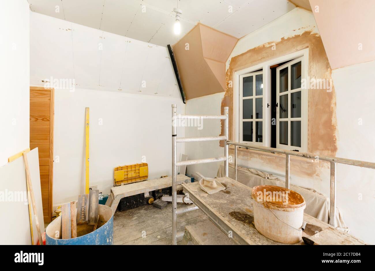 Plâtrage d'une salle, plâtrier installation de cloison sèche dans l'intérieur de la maison avec des outils de plâtrage, maison britannique Banque D'Images