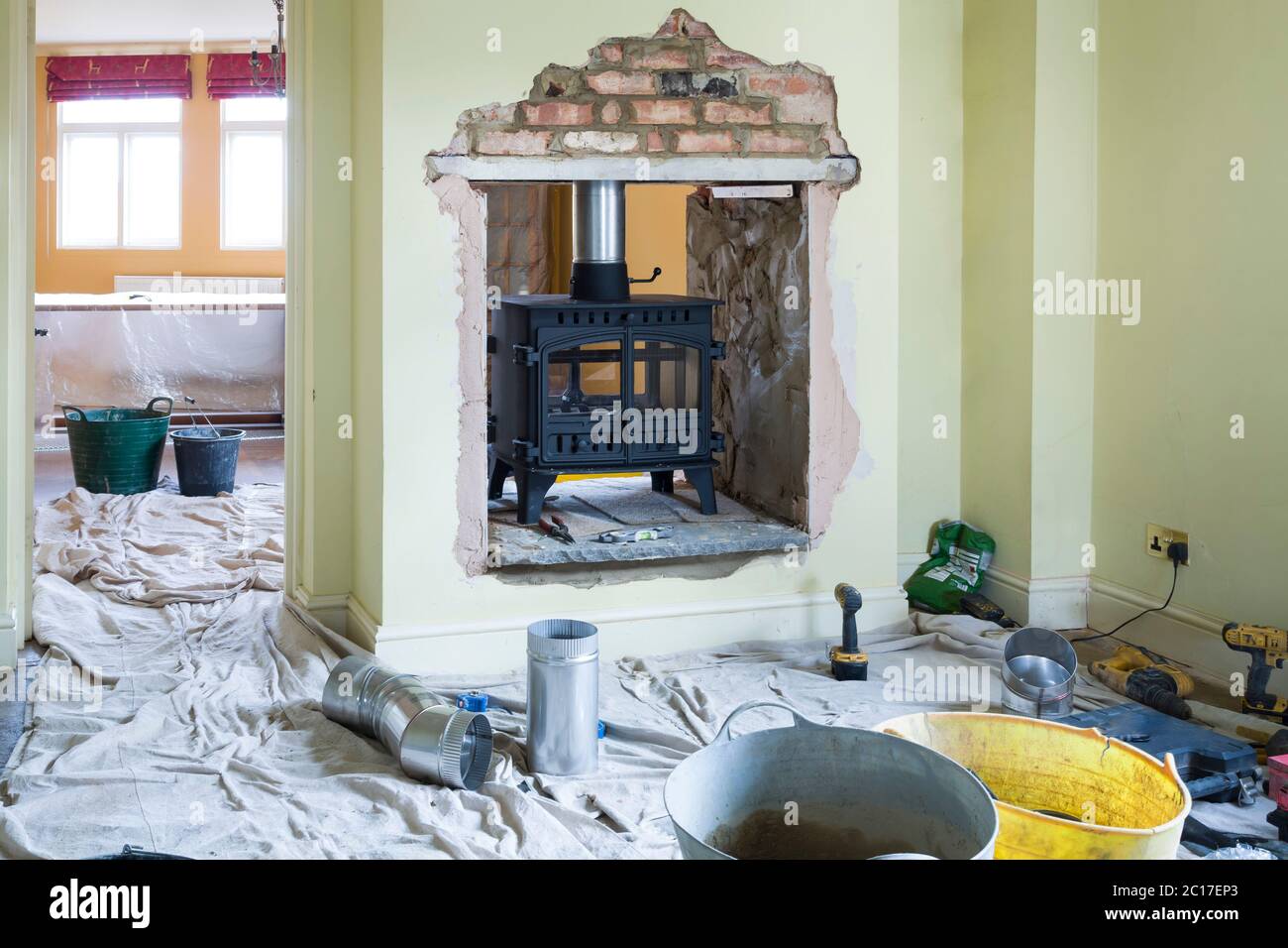 Installation d'un poêle à bois double face pendant un projet d'amélioration de la maison au Royaume-Uni Banque D'Images