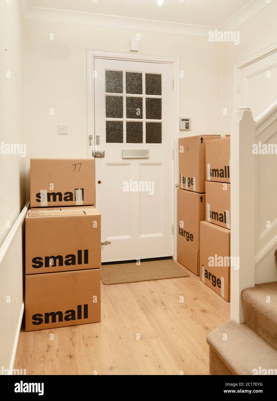 Boîtes en carton emballées et scellées empilées dans une pièce d'une maison, maison mobile, Royaume-Uni Banque D'Images