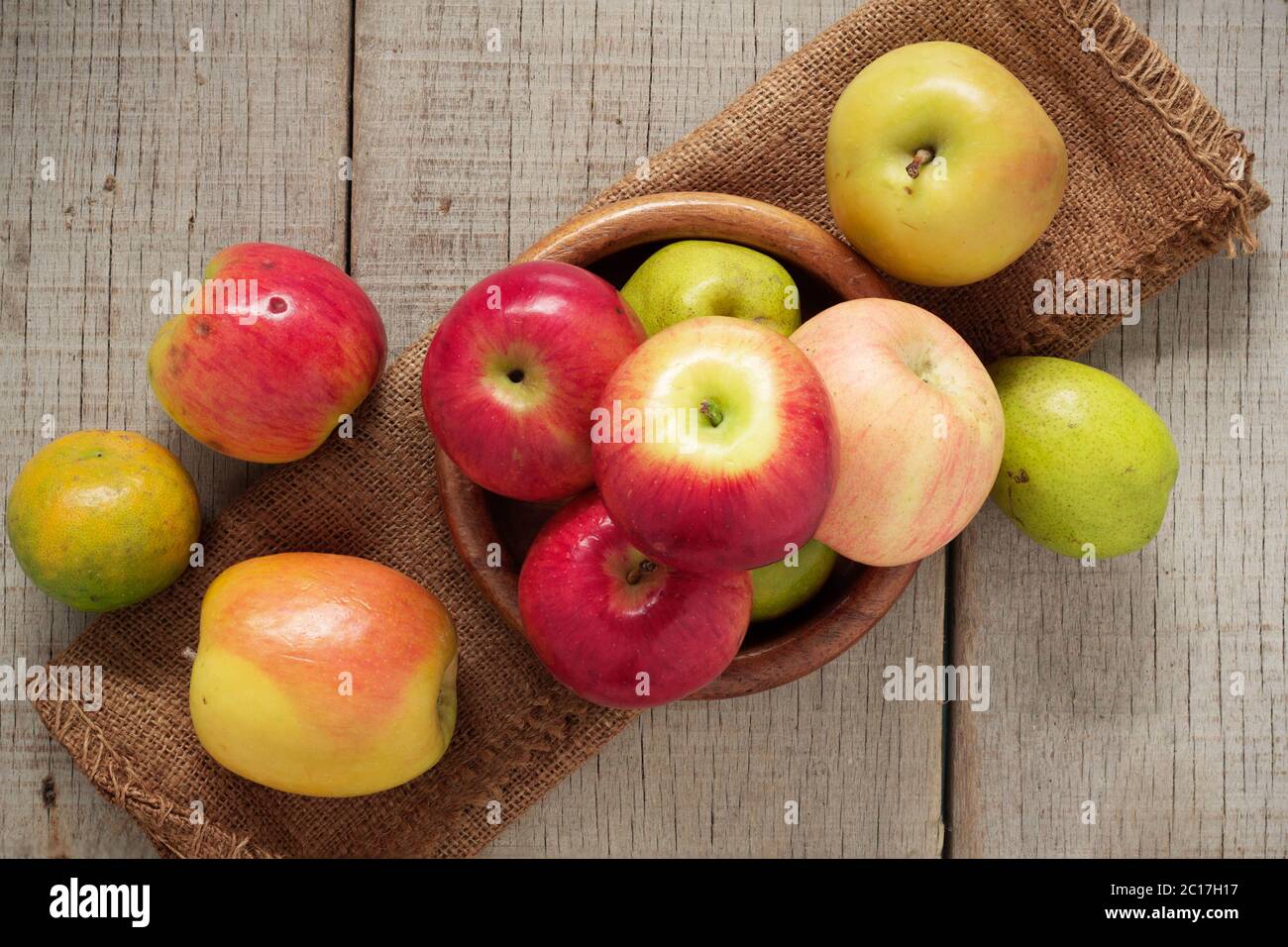 Pommes dans un bol sur bois. Banque D'Images