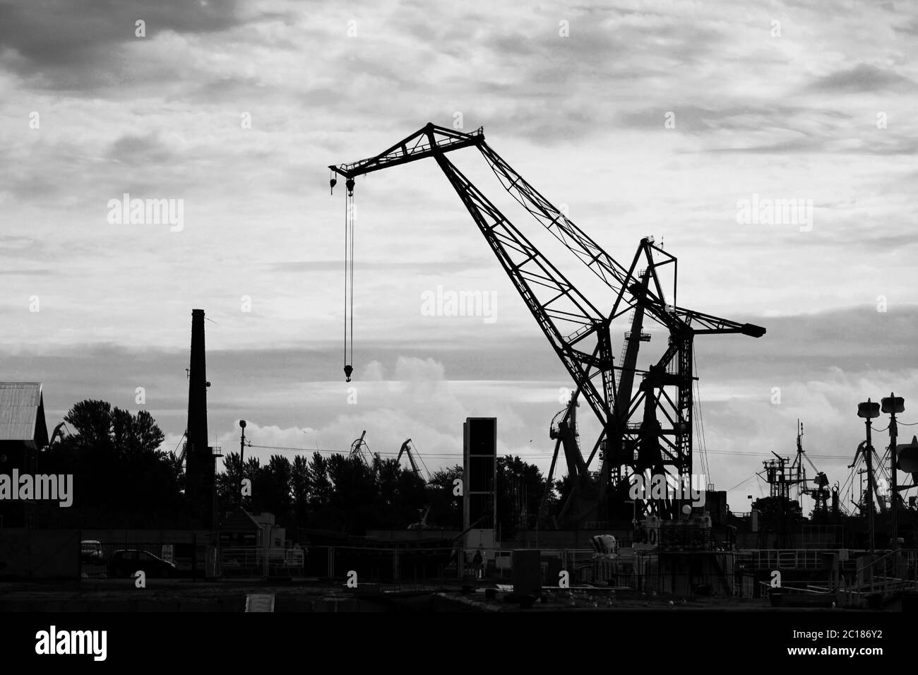 Grue de levage pour le déchargement et le chargement près de la marina pour les navires dans le golfe de Finlande. Photo en noir et blanc Banque D'Images