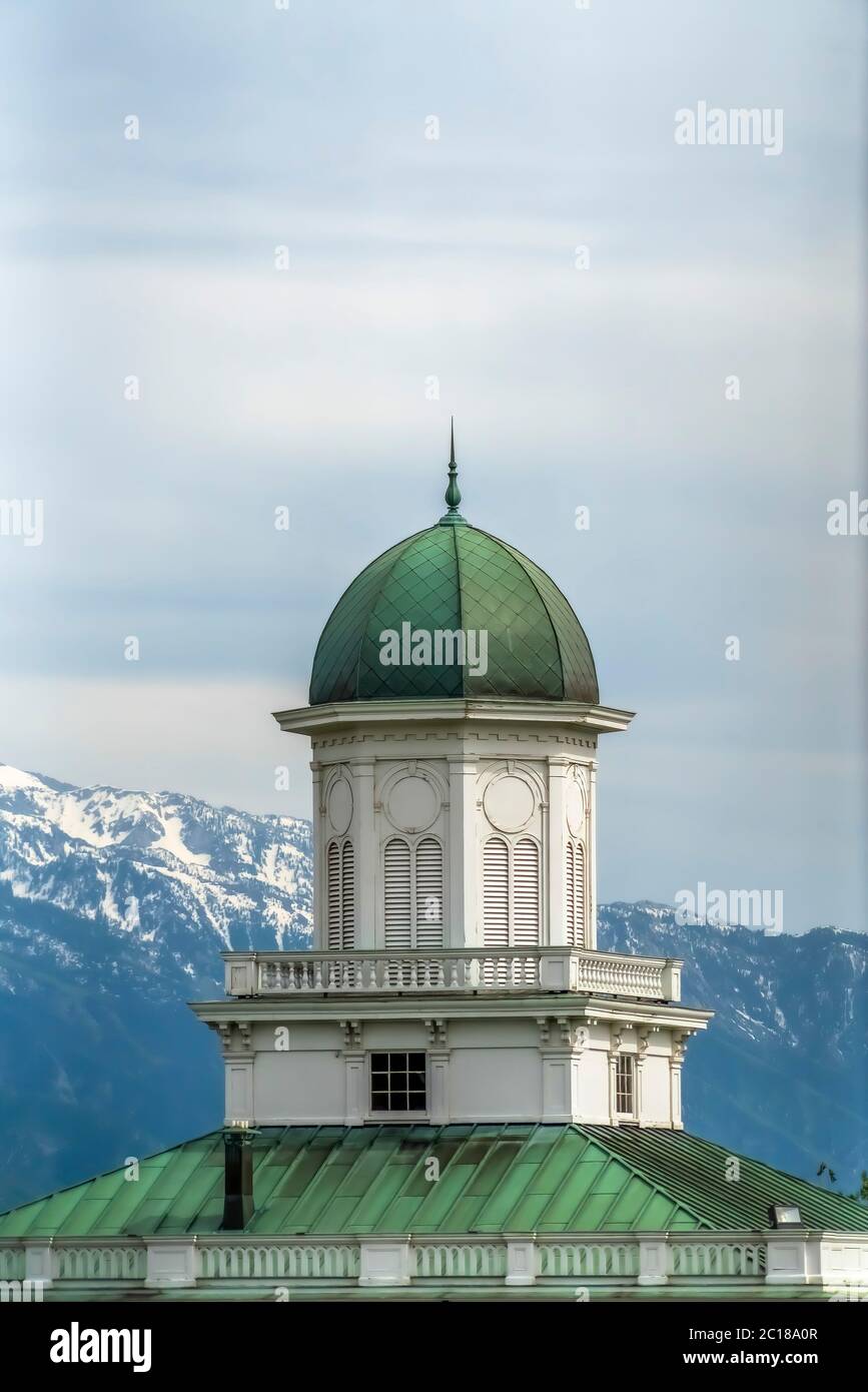 Extérieur du bâtiment avec dôme vert et toit contre la neige et le ciel nuageux Banque D'Images