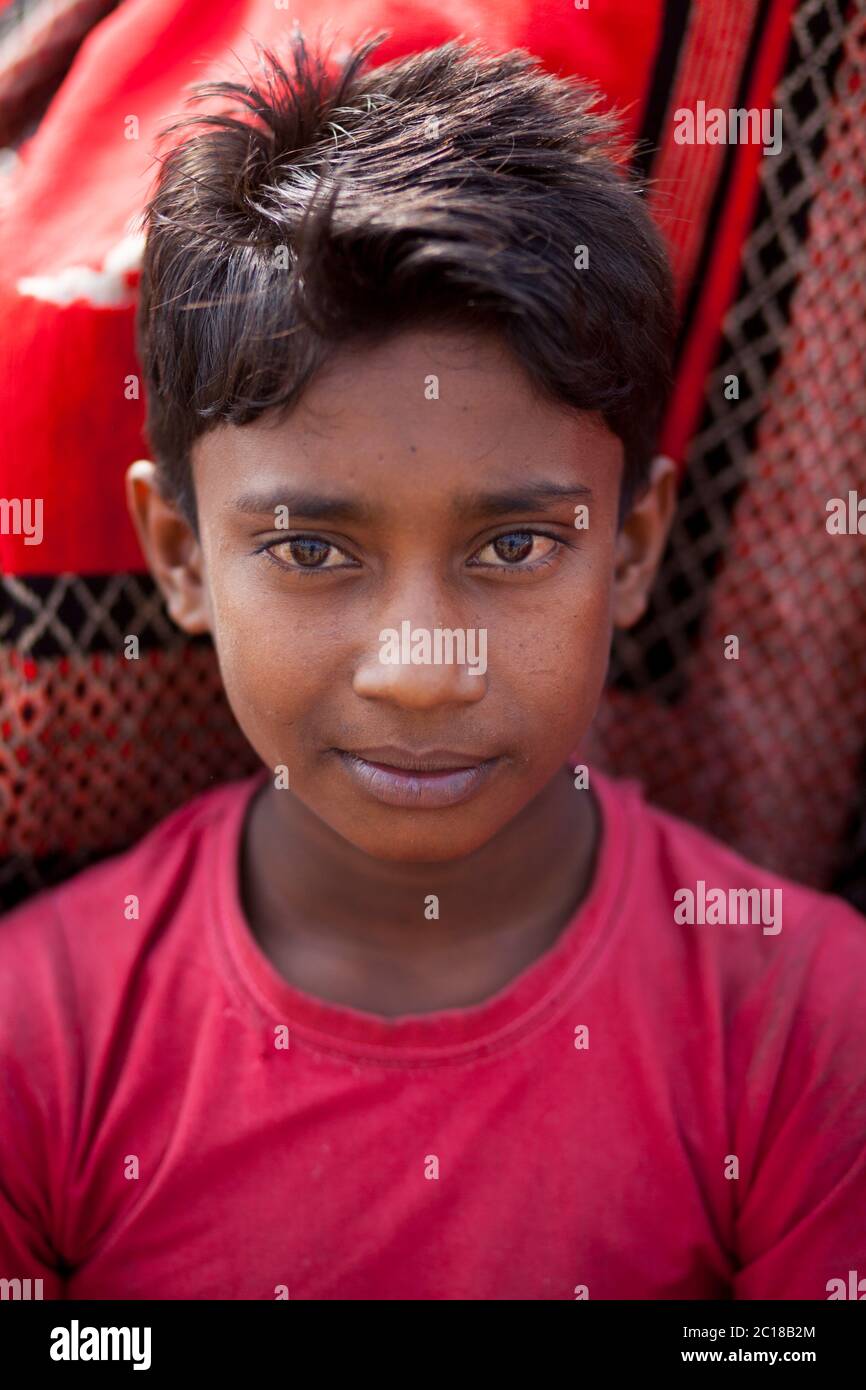 Tareq âge de 11 ans travaillant dans une usine de traitement du riz en gagnant 50 taka (0.65 USD) par jour. Un travailleur pour enfants de l'usine de transformation du riz a travaillé cette aide Banque D'Images